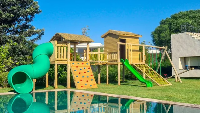 Playground de madeira integrado à piscina, com toboágua, casinhas e ponte pênsil — projeto PG-217