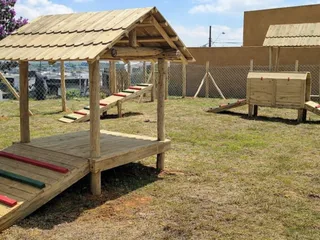 Deck coberto para cães com telhado de madeira, rampas de subida e casinha com rampa lateral