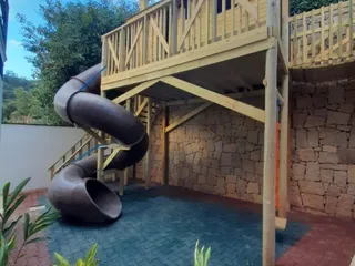 Casa na árvore de madeira construída em torno do tronco, com escada de acesso